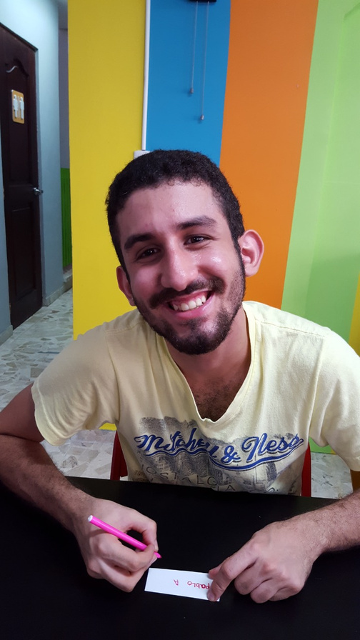Joven de ACEC escribe su nombre en una actividad de aprendizaje funcional