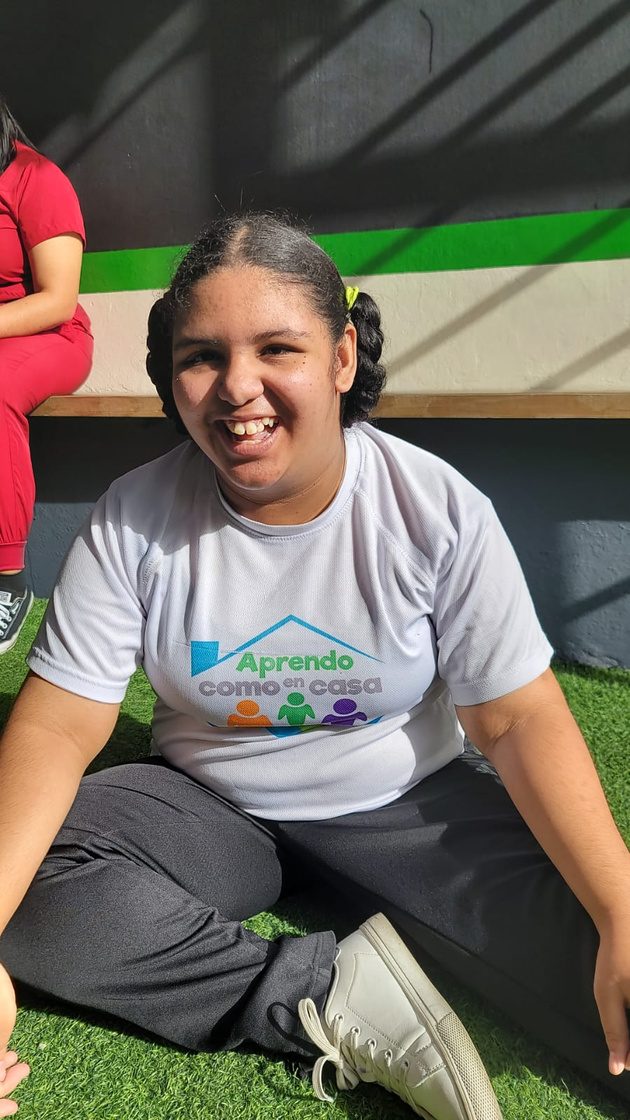 Joven participante de ACEC sonríe en el patio del centro